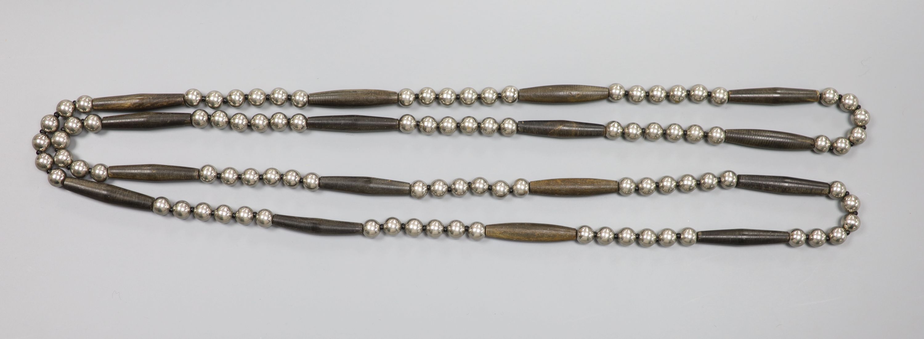 A stylish white metal bead and wooden baton link necklace, 141cm, gross weight 110 grams.